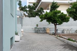 un arbre sur un trottoir à côté d'un bâtiment dans l'établissement casa zervos - Abode of Light, à Loutraki