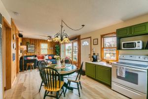 a kitchen with green cabinets and a table with chairs at Lakefront, wildlife Cabin retreat - Sauna optional in Lindstrom