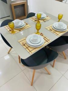 una mesa de comedor con sillas y platos. en MAR doce LAR, en Maceió