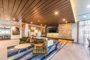 a living room with a table and chairs and a fireplace at Fairfield Inn & Suites by Marriott Corpus Christi Central in Corpus Christi