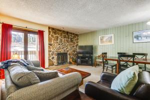 uma sala de estar com sofás e uma parede de pedra em Convenient Winter Park, Colorado, Vacation Rental! em Winter Park