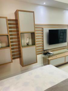 sala de estar con TV y cama en MAR doce LAR, en Maceió