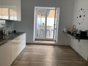 a kitchen with white walls and a wooden floor at Apartamento con gran terraza in Mazarrón