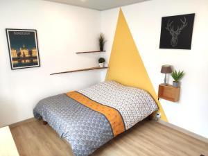 ein Schlafzimmer mit einem Bett mit einem gelben Kopfteil in der Unterkunft Studio ☆ Cité du vin ☆ Stationnement Gratuit dans la rue ☆ Street Park Free in Bordeaux