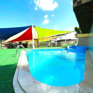 a swimming pool with an umbrella next to a building at Hotel Casa Miller in Panama City