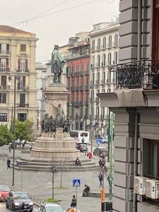 eine Statue mitten in einer Stadt mit Gebäuden in der Unterkunft Amare Napoli in Neapel