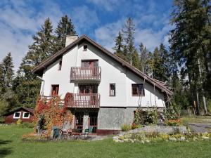 una grande casa bianca con balconi e alberi di Chaty Tatra a Tatranska Strba