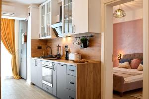 una cocina con armarios blancos y un sofá en una habitación en La Mer by Infinity Resort & SPA, en Mamaia Nord – Năvodari