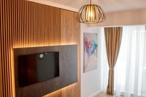 telewizor z płaskim ekranem wiszący na ścianie w obiekcie La Mer by Infinity Resort & SPA w mieście Năvodari
