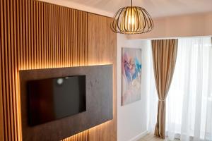 a flat screen tv hanging on a wall at La Mer by Infinity Resort & SPA in Mamaia Nord