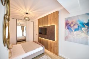 a small bedroom with a bed and a mirror at La Mer by Infinity Resort & SPA in Mamaia Nord +39 photos