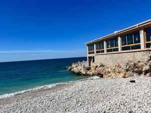 a building on a rocky beach next to the ocean at House with pool and sea view in Bar