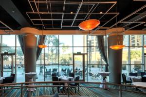 - un restaurant avec des tables, des chaises et de grandes fenêtres dans l'établissement Anaheim Marriott Suites, à Anaheim
