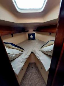 Voilier Sunbeam Yachts 27,5 à quai au Grand Port Aix les Bains في إيكس لي بان: سرير صغير في وسط قارب