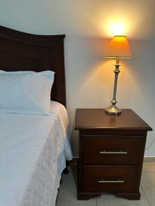 a nightstand with a lamp on it next to a bed at Real Paraiso in Juticalpa