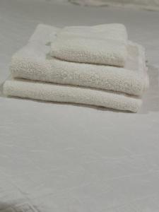 three white towels sitting on top of a bed at Real Paraiso in Juticalpa