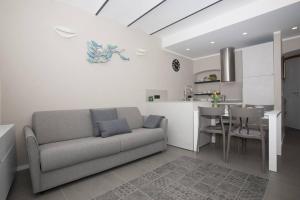 a living room with a couch and a kitchen with a table at Il mare dietro l'angolo in Varazze