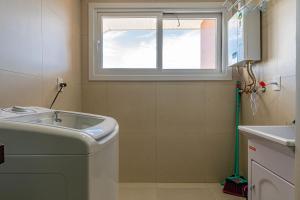 ein Badezimmer mit Waschbecken und Fenster in der Unterkunft Excelente ap em Canela - @stayhousetemporada in Canela + 13 Fotos