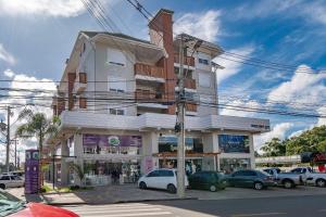 ein Gebäude mit davor geparkten Autos in der Unterkunft Excelente ap em Canela - @stayhousetemporada in Canela