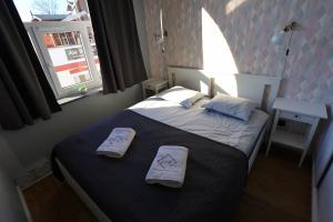 a bedroom with a bed with two towels on it at Apartamenty GREY&WHITE in Ciechocinek