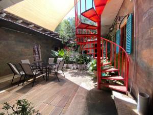 un patio con scala rossa, tavolo e sedie di Velvet hotel centro histórico a Santa Ana