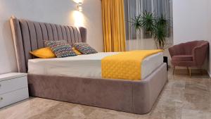 a bedroom with a large bed with yellow pillows at KYA Luxury in Mamaia