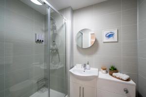 a white bathroom with a sink and a shower at Personal En-suite in Shrewsbury