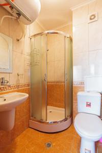 a bathroom with a shower and a toilet and a sink at Apartment Patriarh Evtimiy in Burgas