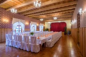 salę bankietową z białymi stołami i krzesłami w obiekcie Hotel Penzion Trámky w mieście Vikýřovice
