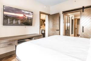 um quarto com uma cama branca e um quadro na parede em Canyons Village Condos by All Seasons Resort Lodging em Park City