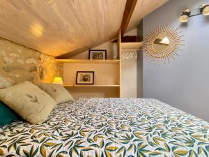 Schlafzimmer mit einem Bett und einem Spiegel in der Unterkunft Le chant des oiseaux in Tourliac
