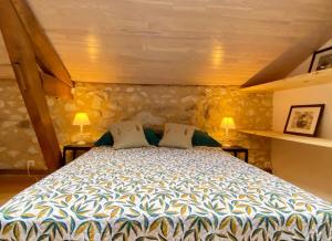 ein Schlafzimmer mit einem großen Bett mit zwei Kissen in der Unterkunft Le chant des oiseaux in Tourliac