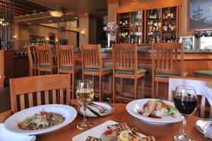 a table with plates of food and glasses of wine at Banff Ptarmigan Inn in Banff