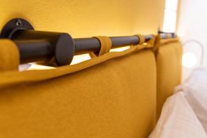 a close up of a towel rack next to a bed at Bella Vasilica Luxury Apartments in Parga +79 photos