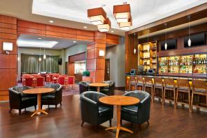 ein Restaurant mit Tischen und Stühlen und eine Bar in der Unterkunft Grand Park Hotel Vancouver Airport in Richmond