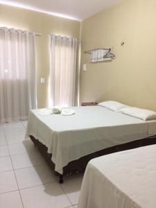 Un dormitorio con una cama grande y una ventana en Hana Praia Hotel, en Camocim