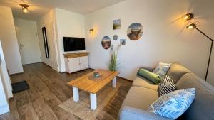 ein Wohnzimmer mit einem Sofa und einem Tisch in der Unterkunft Strandbox & Strandresidenz in Norderney