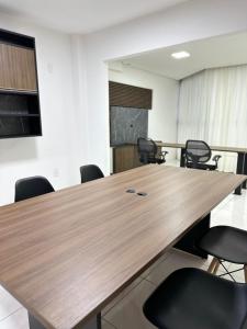 a conference room with a wooden table and chairs at Nacional Hotel Coral in Lages