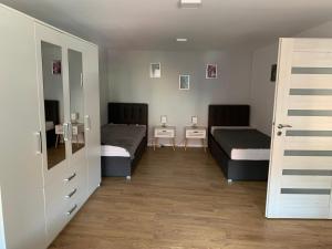 een kamer met 2 bedden en een spiegel bij Apartament Zofia in Duszniki Zdrój