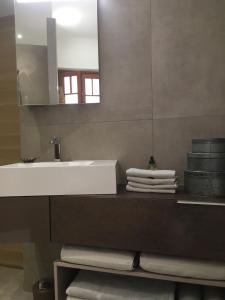 Un baño con lavabo, espejo y toallas. en Ma terrasse sur le musée, en Chambéry