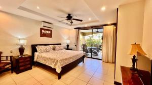 a bedroom with a bed and a sliding glass door at Monte Carlo Luxury Condominiums in Jacó