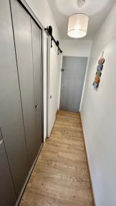 un corridoio con pavimento in legno e una camera con porta di Le Yachting vue mer a Le Barcarès