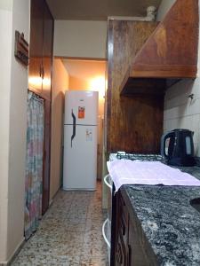 a kitchen with a white refrigerator in a hallway at Depto 4-6 Personas in San Juan