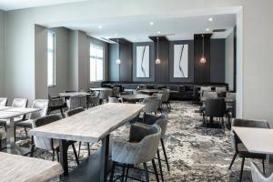 - une salle à manger avec des tables, des chaises et des fenêtres dans l'établissement Fairfield Inn & Suites by Marriott Boston Logan Airport/Chelsea, à Chelsea