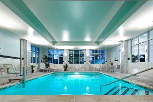 - une grande piscine d'eau bleue dans un bâtiment dans l'établissement Fairfield Inn & Suites by Marriott Boston Logan Airport/Chelsea, à Chelsea