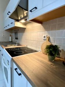 a kitchen with white cabinets and a stove top oven at Kaloudis Studios & Apartments in Dassia