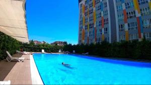 eine Person, die in einem Pool neben einigen Gebäuden schwimmt in der Unterkunft Antalya LEGOLAND COMPLEX Near the AIRPORT in Antalya