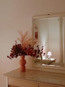 un vaso seduto su un tavolo di fronte a uno specchio di CASA VACANZE ALBA a Pozzallo