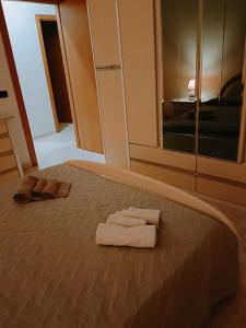 un letto con due asciugamani e due pantofole sopra di CASA VACANZE ALBA a Pozzallo