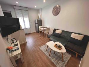 salon z kanapą i stołem w obiekcie Arcueil 2P Moderne Proche RER B w mieście Arcueil